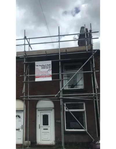 House with scaffolding and construction sign
