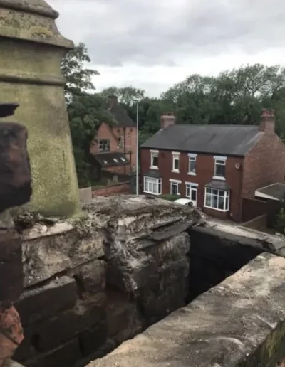 View from tall bridge to nearby houses and trees.
