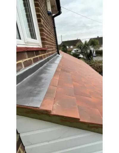 Brick house with sloped orange tile roof.
