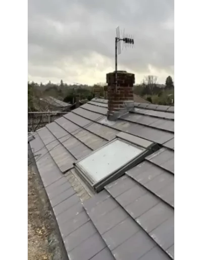 Slate roof with chimney and TV antenna.