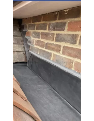 Brick house roof corner with flashings.