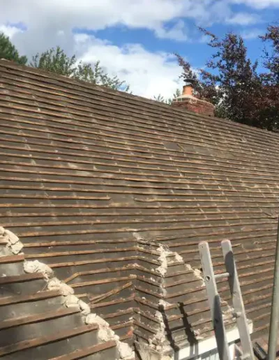 Roof renovation in progress on house.