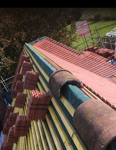 Rooftop construction with red tiles and wooden beams.