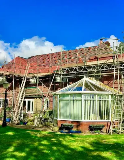 House under renovation with scaffolding and ladders.