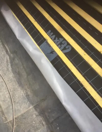 Roofing underlayment with yellow stripes and label.